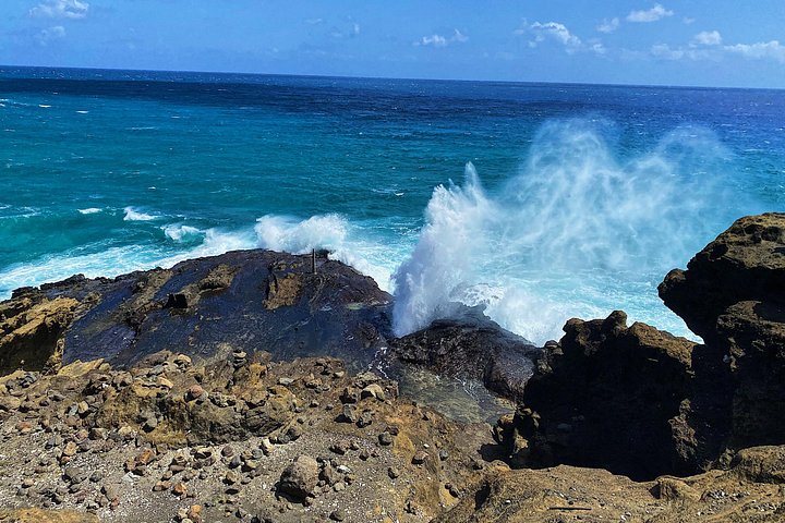 Ocean wave crashing against dark volcanic rocks