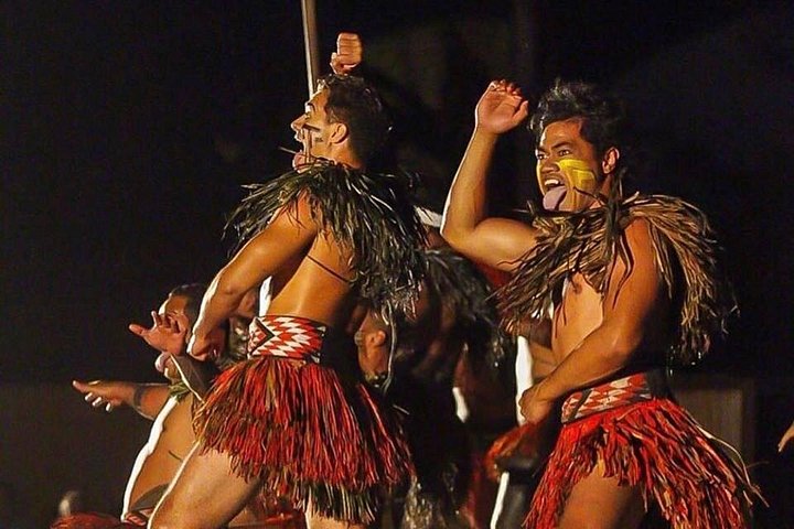 Dancers in red skirts performing with raised hands