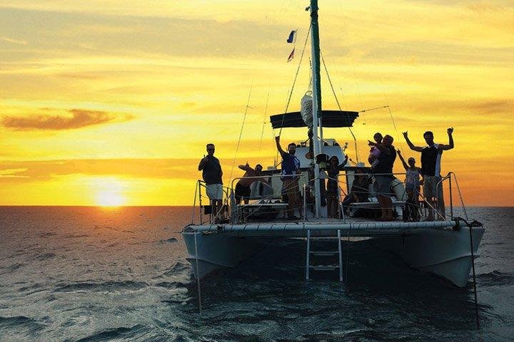 People on a boat at sunset at sea